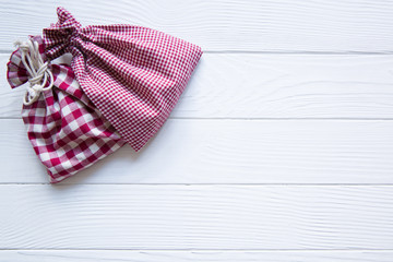 Christmas red chequered sacks on white wooden rustic background, copy space. Mery Christmas and a happy New year.