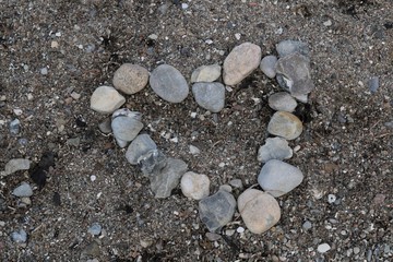 a heart build out of stones as a background at the beach - obrazy, fototapety, plakaty