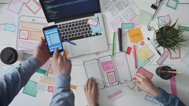 Small team of UX designers discussing app wireframe