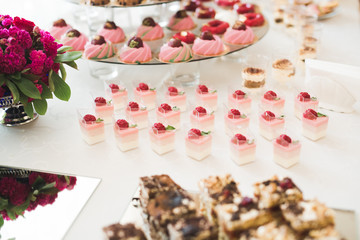 Naklejka na ściany i meble Delicious and tasty dessert table with cupcakes shots at reception closeup