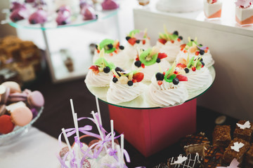 Delicious sweets on wedding candy buffet with desserts, cupcakes