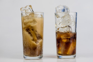 Cold drink with ice in a glass on a white table. A way to cool down on hot days.