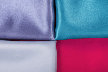 Background of colorful fabrics red green pearl and purple.