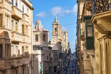 Fototapeta na wymiar Old narrow street with colorful balconies in historical part of Valletta in Malta