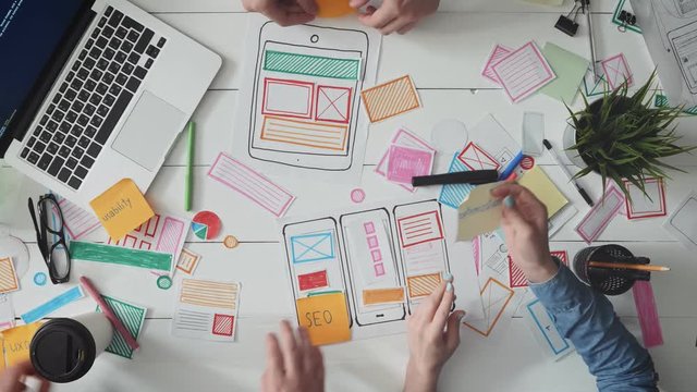 UX designers putting post it notes on app layout