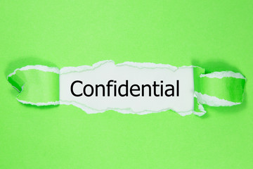 The word confidential appearing behind torn paper.