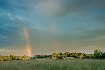 Calm summer evening with double rainbow