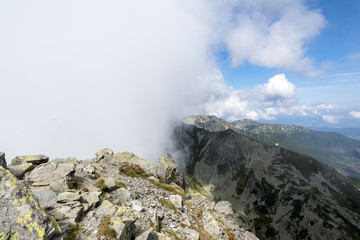 mountain ridge covered by half with the cloud