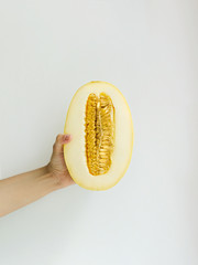 Melon Front view Girl is holding a half of ripe melon against white background Photo in minimalist style with copy space