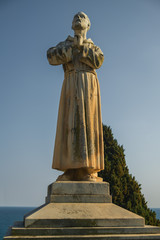 Fototapeta premium Betende Statue vor blauem Himmel in goldenem Licht