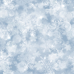 Christmas seamless pattern with white blurred snowflakes, glare and sparkles on light blue background