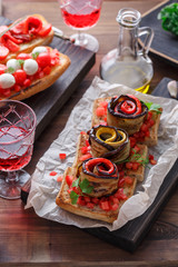 Bruschetta with tomato, basil and mozzarella cheese on wooden board. Traditional italian appetizer or snack, antipasto