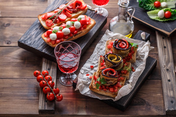 Bruschetta with tomato, basil and mozzarella cheese on wooden board. Traditional italian appetizer or snack, antipasto