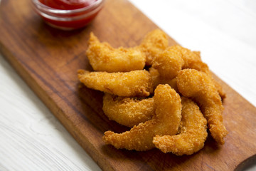 Fried shrimps tempura with sauce on rustic wooden board over white wooden background, closeup.