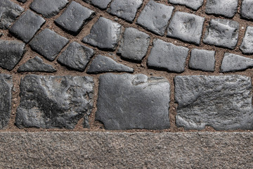 gray paving stone, with sand, lit by the sun