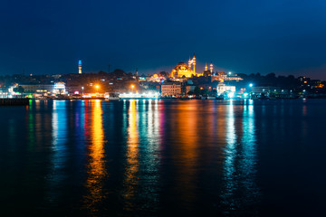 Obraz premium Night view of Istanbul. Panorama cityscape of famous tourist destination Golden Horn bay part of Bosphorus strait. Travel illuminated landscape Bosporus, Turkey, Europe and Asia.