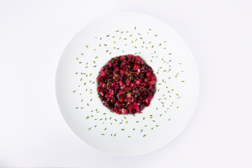 Salad with beets. Vinegret is a traditional Russian salad made from beets and vegetables in a white plate. The background is white. Top view. Copy space. Horizontal shot.