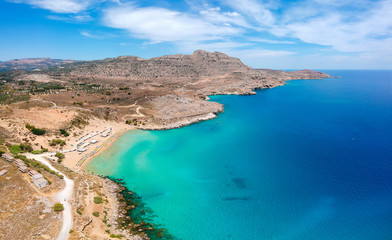 Fototapeta na wymiar Aerial birds eye view drone photo Agia Agathi beach near Feraklos castle on Rhodes island, Dodecanese, Greece. Panorama with sand beach and clear blue water. Famous tourist destination in South Europe