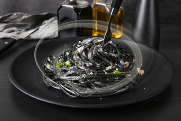 Pasta with wheat germ and black squid ink. Mushroom sauce. Olive oil and spices. Copy space.