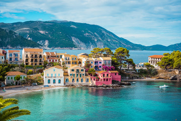 Assos village. Beautiful view to vivid colorful houses near blue turquoise colored transparent bay...