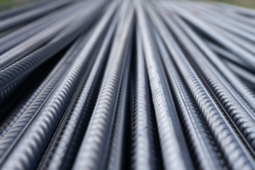 Stack of heavy metal reinforcement bars with periodic profile texture. Close up steel construction...