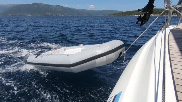 Dinghy being towed by sailboat