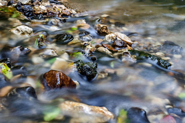 A stony streambed, a stream of clear water. Stream Repinka in the city of Obninsk, Russia
