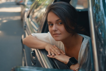 Obraz na płótnie Canvas Young woman in casual wear Put Head Out of Window while driving
