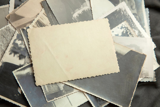 Stack old photos on table. Mock-up blank paper. Postcard rumpled and dirty vintage