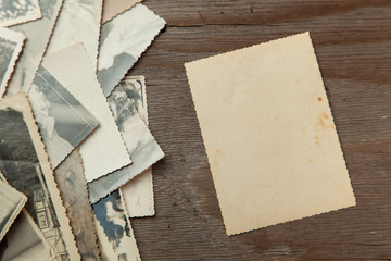 Stack old photos on table. Mock-up blank paper. Postcard rumpled and dirty vintage