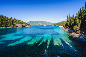 Beautiful Phoki Beach surrounded by cypress trees in the evening sunlight. Amazing seascape of...