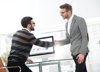 Business associates shaking hands in office