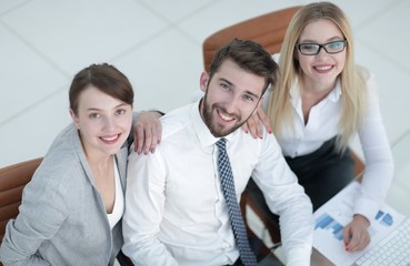 successful business team sitting at table and looking at camera.