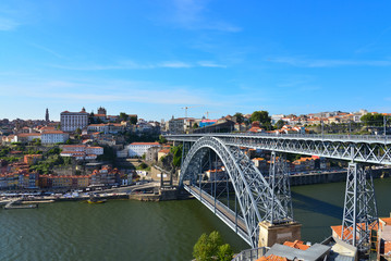 Naklejka premium Panoramic landscape view of Dom Luis Bridge, Luís I Bridge, which is iconic arched metal bridg, riverside of Douro river and old town cityscape on the hill in Porto, Portugal, Europe