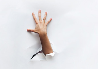 The hand reaches to something. A hand breaks through the obstacle and tries to grab something. Secret desire. Stealing.