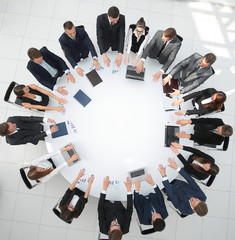 group of business people sitting at the round table, and putting his palms on the table