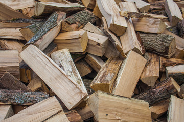 Woodpile of chopped lumber. Pile of wood logs. Stacked firewood timber
