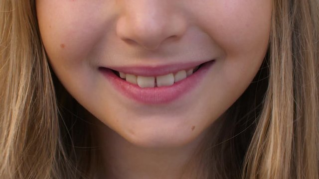 Cheerful girl with toothy smile and pink lips, partial view
