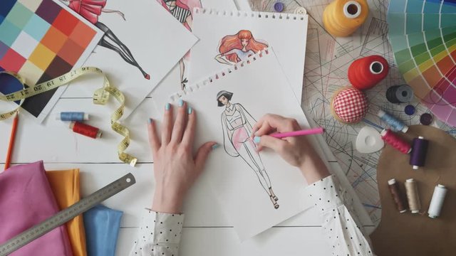 Fashion designer drawing clothes sketch