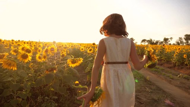 little girl running across the field with sunflowers at sunset. slow motion video. girl runner in the field at sunset lifestyle sunflowers. girl sunlight runs the concept of sunflowers