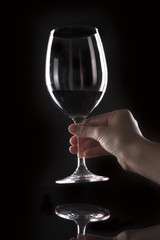 woman hand hold a glass on the black