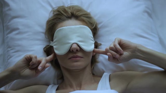 Irritated female lying uncomfotably, bad day, annoying noise, tolerate urban din