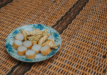 Lemang and ketupat (bamboo rice and rice dumpling) with rendang on bamboo mat.