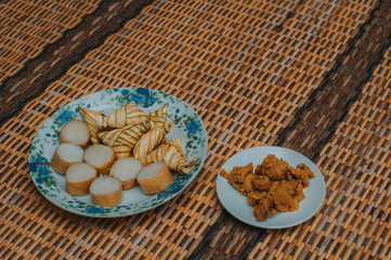 Lemang and ketupat (bamboo rice and rice dumpling) with rendang on bamboo mat.