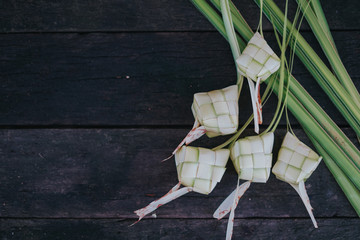Ketupat (rice dumpling) on vintage wood background.Famous traditional food during celebration of Eid Ul Fitr and Eid ul Adh.