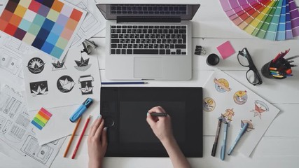 Creative designer using graphics tablet while working at her table - Powered by Adobe
