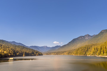 lake among the mountains covered with dense forests, a building on the lake