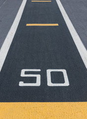 Runway of airport guideline, take off and 50 percent sign printed on the asphalt Takeoff runway and runway aircraft carrier on battleship. Public area.