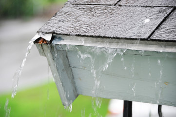 close up on rain flowing down the roof