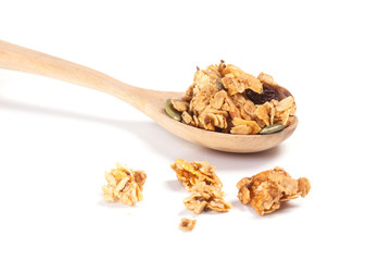Close up Granola on the wooden spoon isolated on white background.